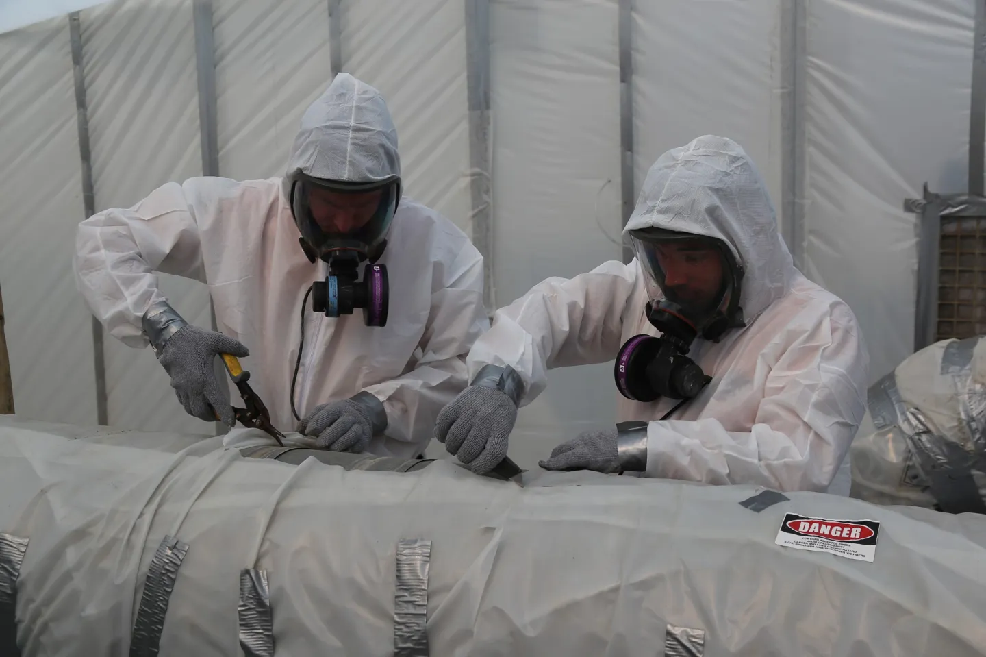 Axis Remedial Sciences technicians in full protective equipment performing asbestos abatement